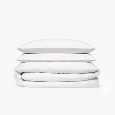 Conjunto de duas almofadas brancas e um edredão branco dobrado