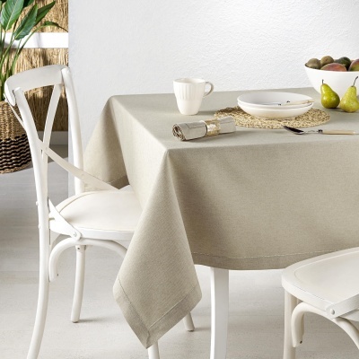 Toalha cinza claro sobre mesa com cadeiras brancas e utensílios simples sobre a mesa