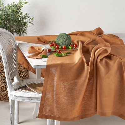 Toalha de mesa castanha clara sobre mesa branca de madeira com legumes frescos