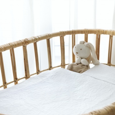 Berço de bebé em vime com coelho de peluche branco