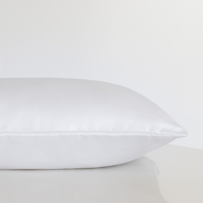 Travesseiro branco com capa lisa sobre superfície branca