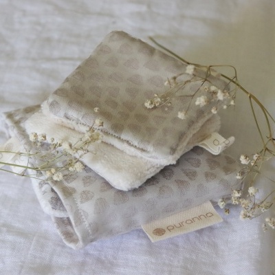 Dois pares de meias cinza com padrão de pontos e etiqueta purranna sobre tecido branco com flores secas