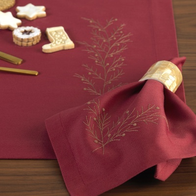 Toalha de mesa e guardanapo vermelhos com bordados dourados e biscoitos decorativos