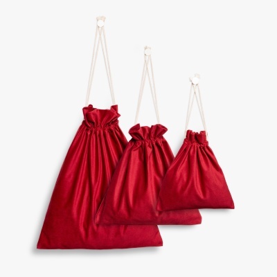 Três sacos vermelhos com cordões brancos pendurados