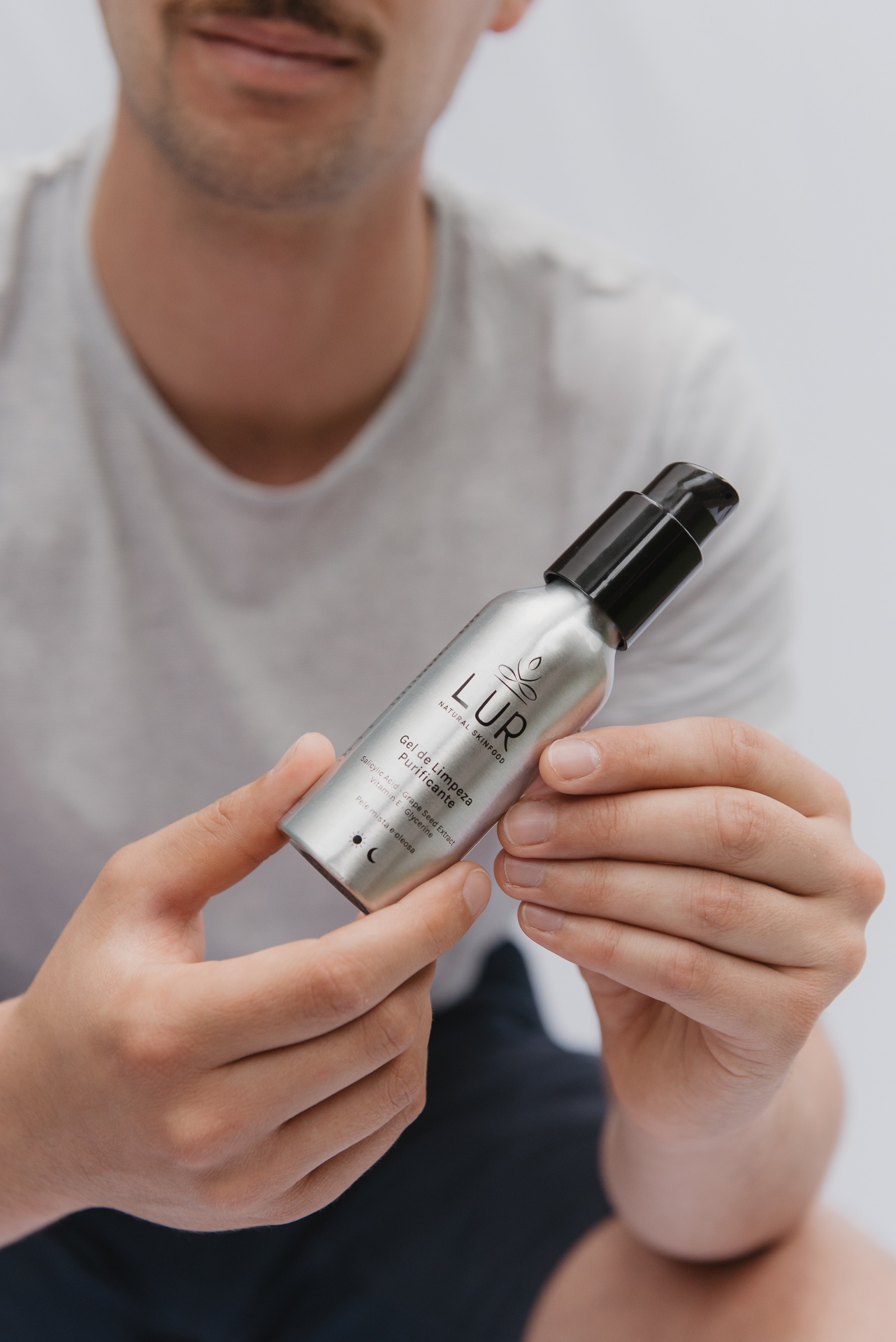 Gel de Limpeza Purificante Frasco prateado com tampa preta de Gel de Limpeza Purificante LUR nas mãos de uma pessoa.