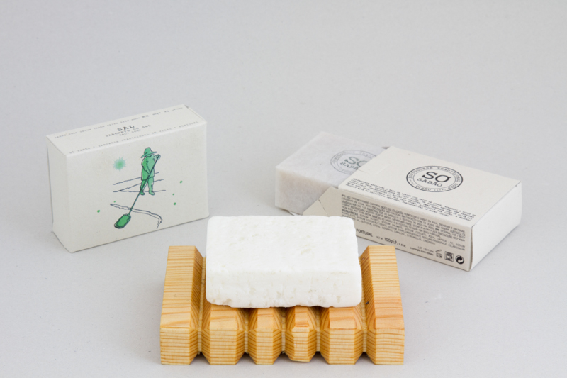 Sabonete de Sal Marinho Barra de sabão branco em saboneteira de madeira com caixas de papel branco ao fundo