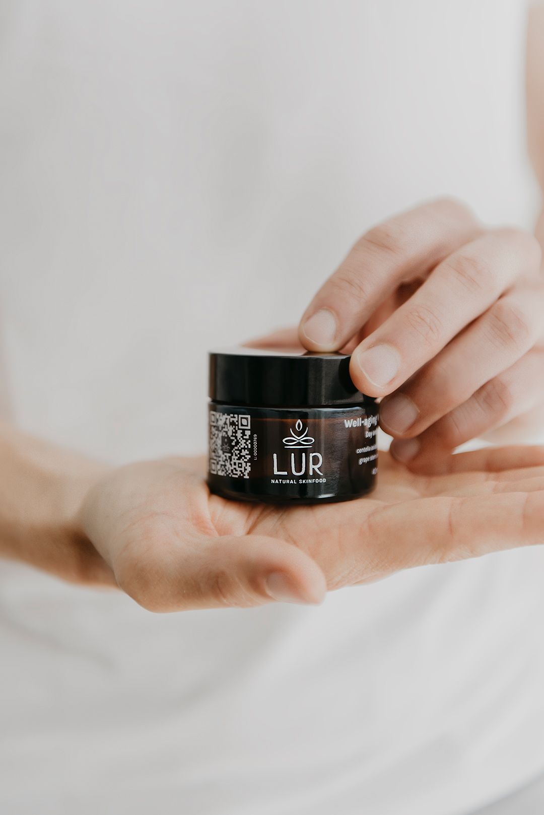 Creme Facial Vegan Well-Aging Frasco pequeno de creme LUR Natural Skinfood na mão