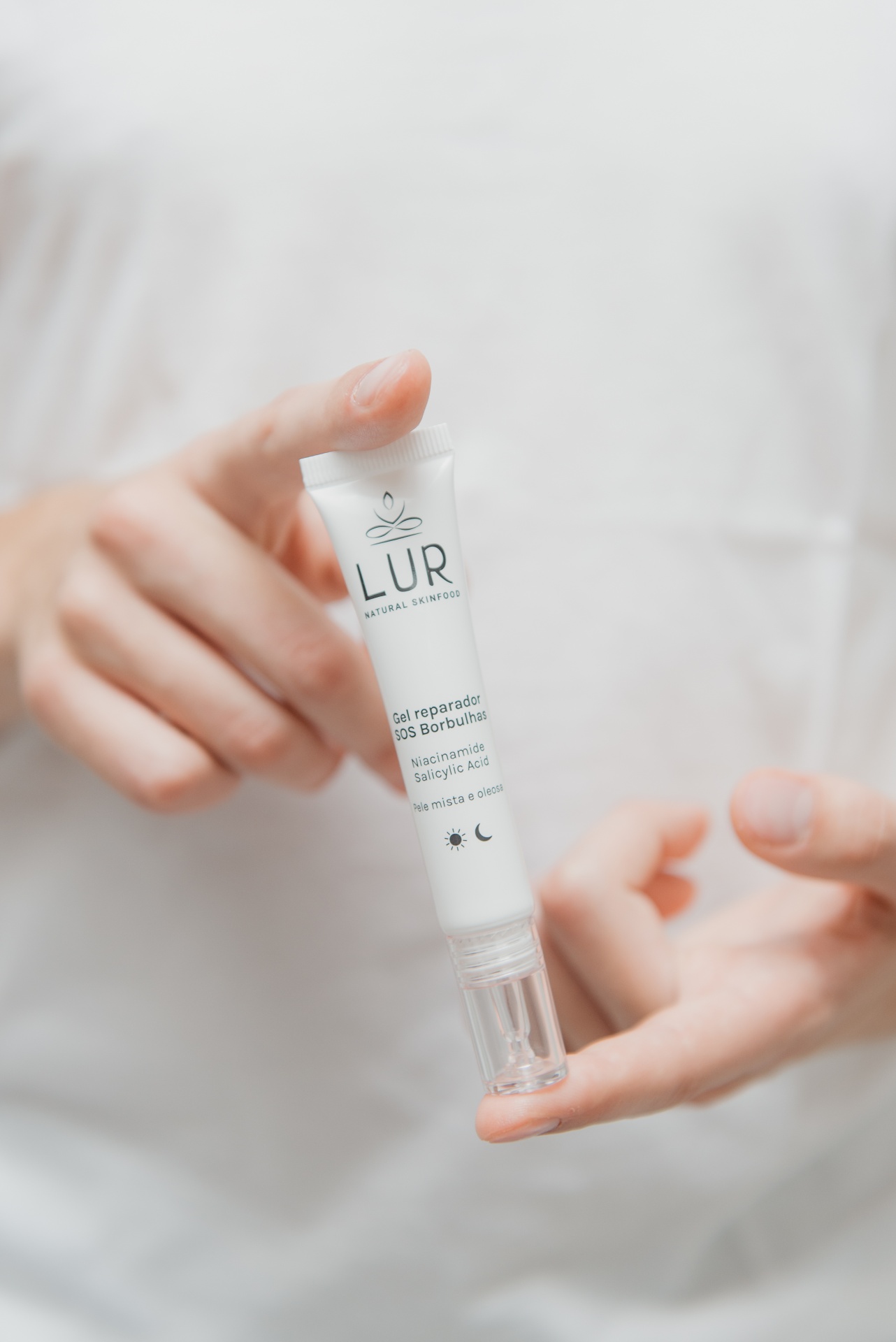 Gel Reparador SOS Borbulhas Mãos seguram tubo branco de gel reparador SOS Borbulhas da marca LUR