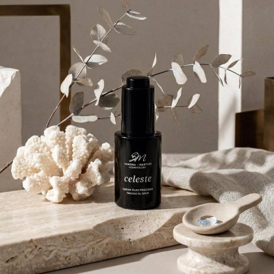 Frasco preto de sérum com coral branco e ramo seco sobre pedra clara.