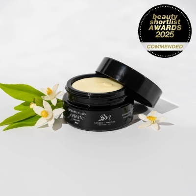 Frasco aberto de bálsamo facial Celeste com flores e selo de prémio