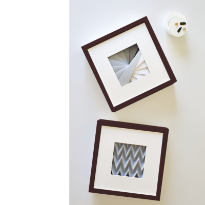 Dois quadros com padrões geométricos, fundo branco, colher e frasco ao lado