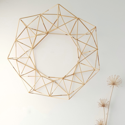 Estrutura decorativa circular de madeira em padrão geométrico na parede branca