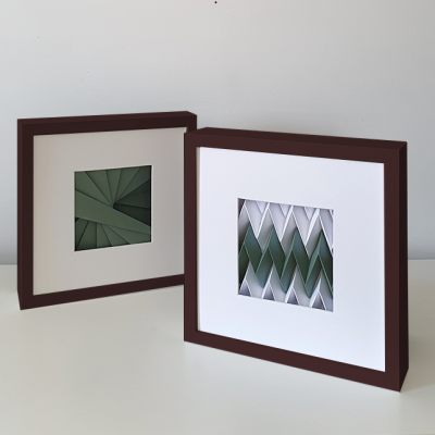 Dois quadros com arte geométrica tridimensional em tons de verde e branco com molduras castanho-escuras