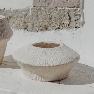 Vaso decorativo de cerâmica branca rugosa em superfície branca