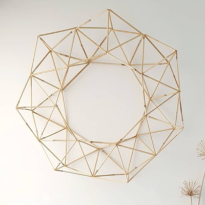 Estrutura decorativa geométrica circular de bastões bege claro na parede