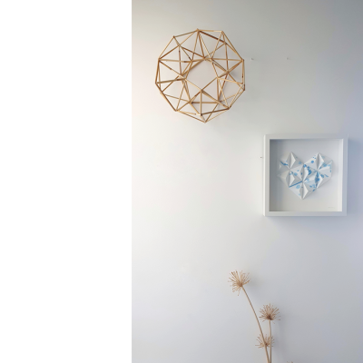 Decoração de parede com objeto geométrico em madeira e quadro branco com arte de origami azul e branca