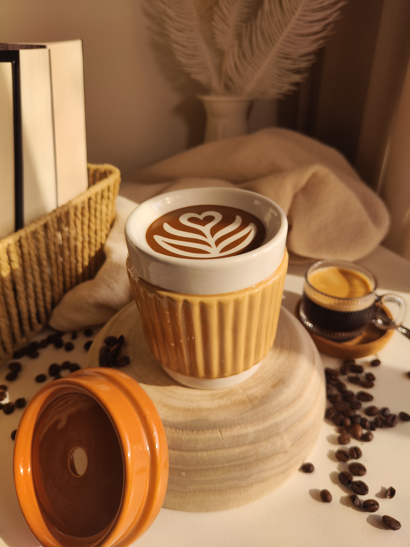 Queimador Copo de café Conjunto de chávena de cerâmica com café decorado ao lado de copo de vidro com expresso e grãos de café