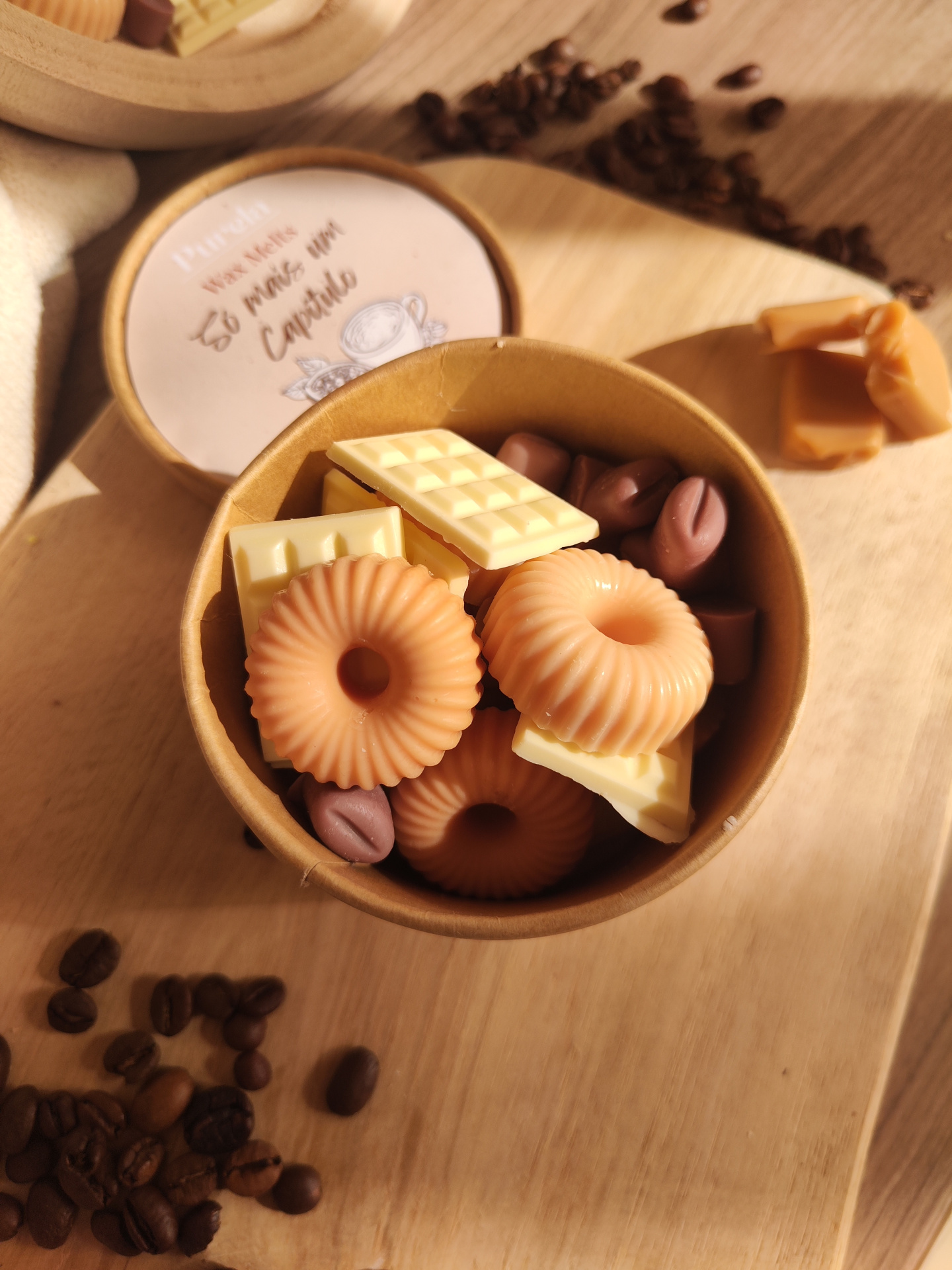 Wax Melt Só mais um Capítulo caixa de cartão com velas de cera e grãos de café sobre mesa de madeira clara