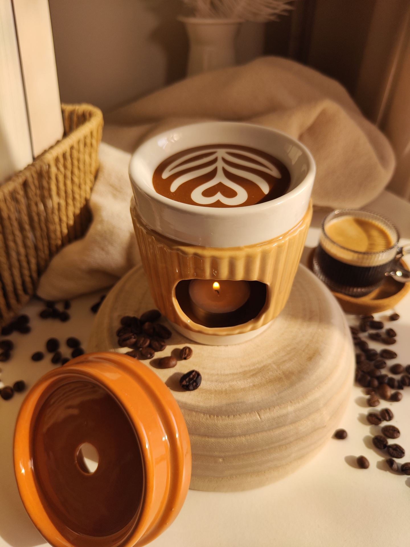 Queimador Copo de café Difusor ou aquecedor cerâmico com vela acesa, base de madeira, grãos de café e xícara.
