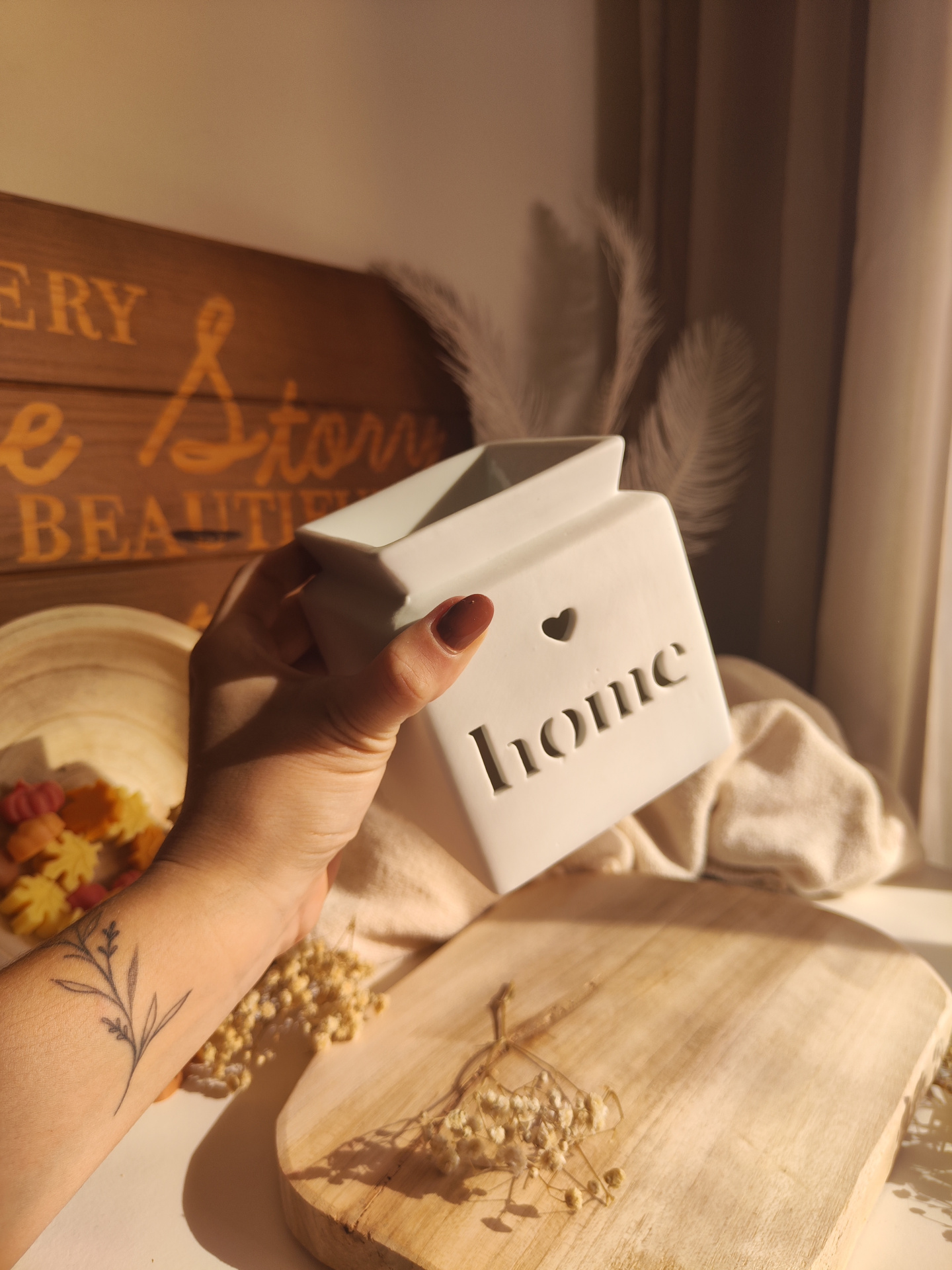 Queimador Casa Vaso cerâmico branco com a palavra home e coração, em ambiente decorativo acolhedor