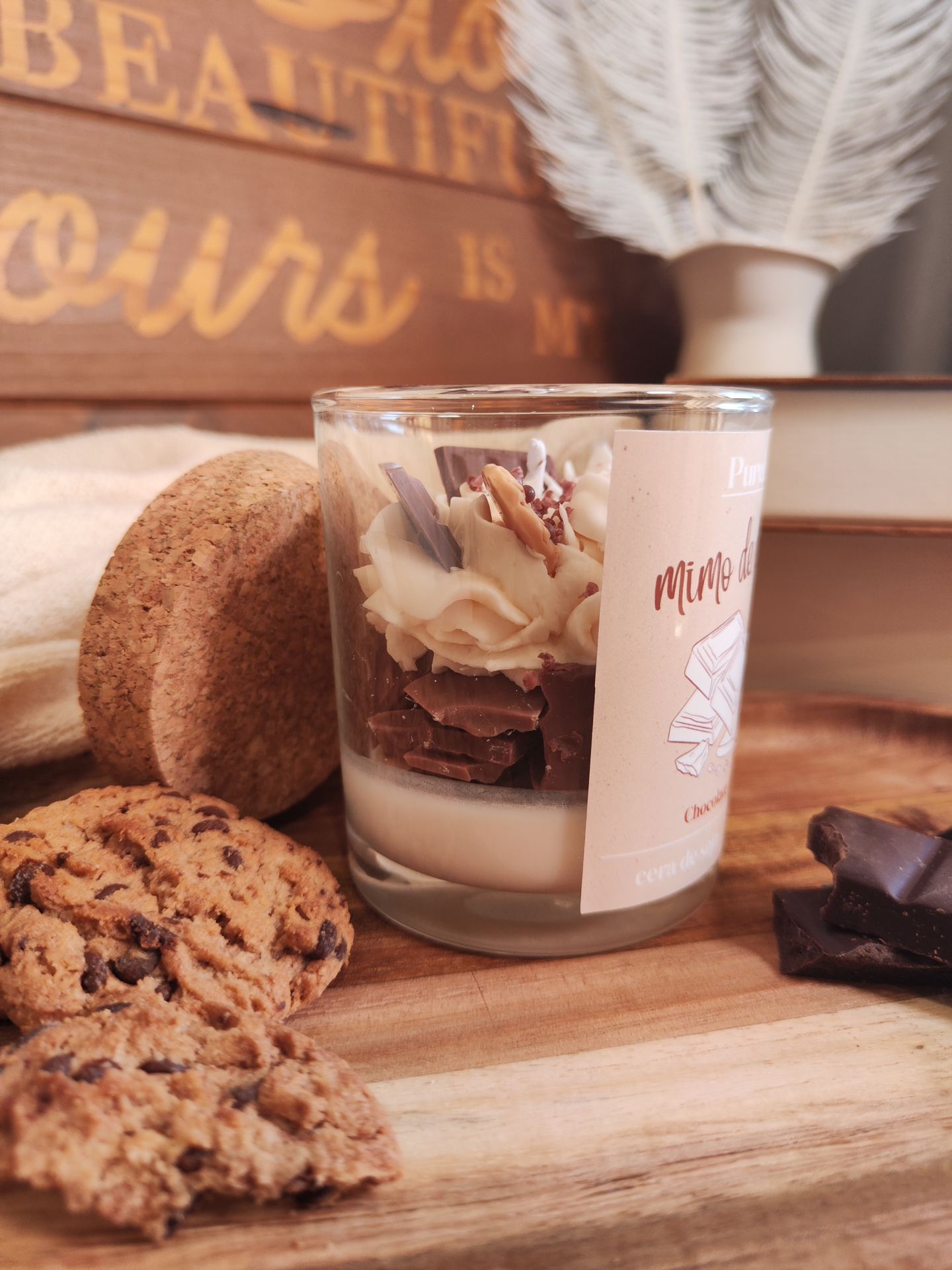 Vela Mimo de Cacau Vela em copo de vidro com decoração tipo chocolate e bolachas ao lado sobre madeira