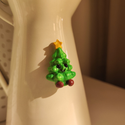 Caneca bege com decoração de árvore de Natal verde brilhante sorridente e estrela amarela no topo.
