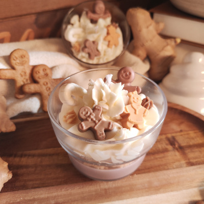 Taças com creme e biscoitos em forma de bonecos com gengibre e biscoitos em madeira