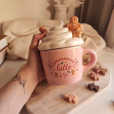 Caneca rosa com tampa chantilly e decoração de homem de gengibre