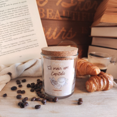 Vela perfumada Purela com tampa de cortiça e croissants ao lado de livros e café