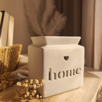 Frasco decorativo branco de cerâmica com recorte da palavra home e corações