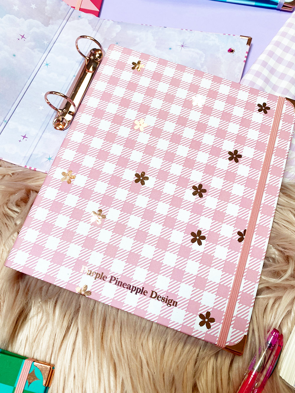 Caderno rosa e branco xadrez com flores douradas e elástico