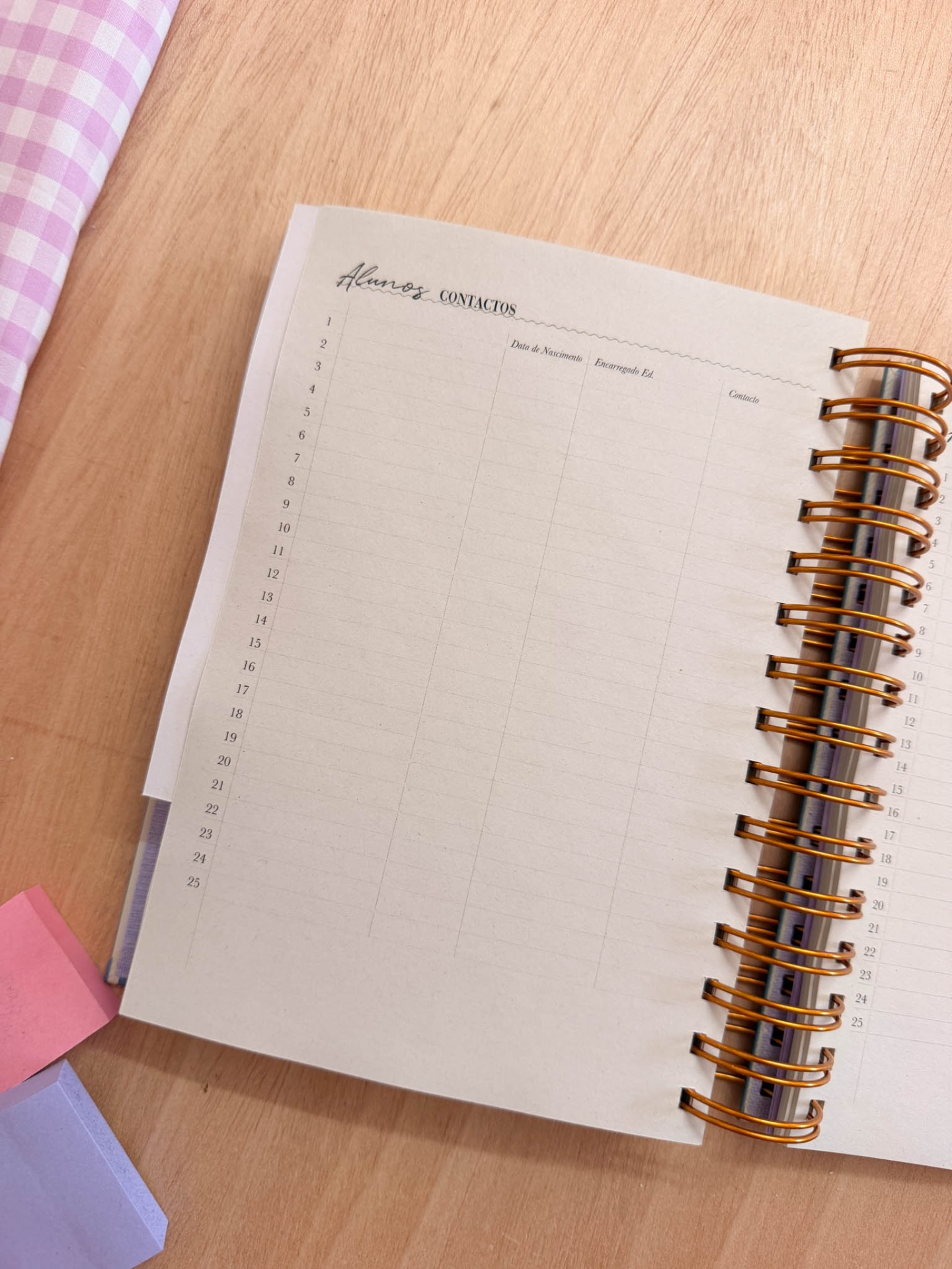 Caderno com páginas para registar contactos de alunos numa mesa de madeira