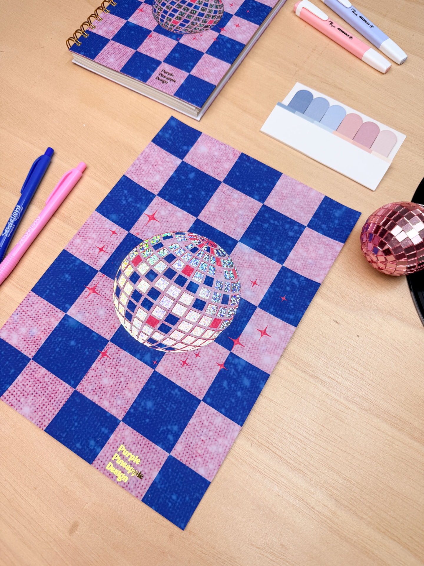 Caderno e folha com padrão xadrez e esfera espelhada holográfica