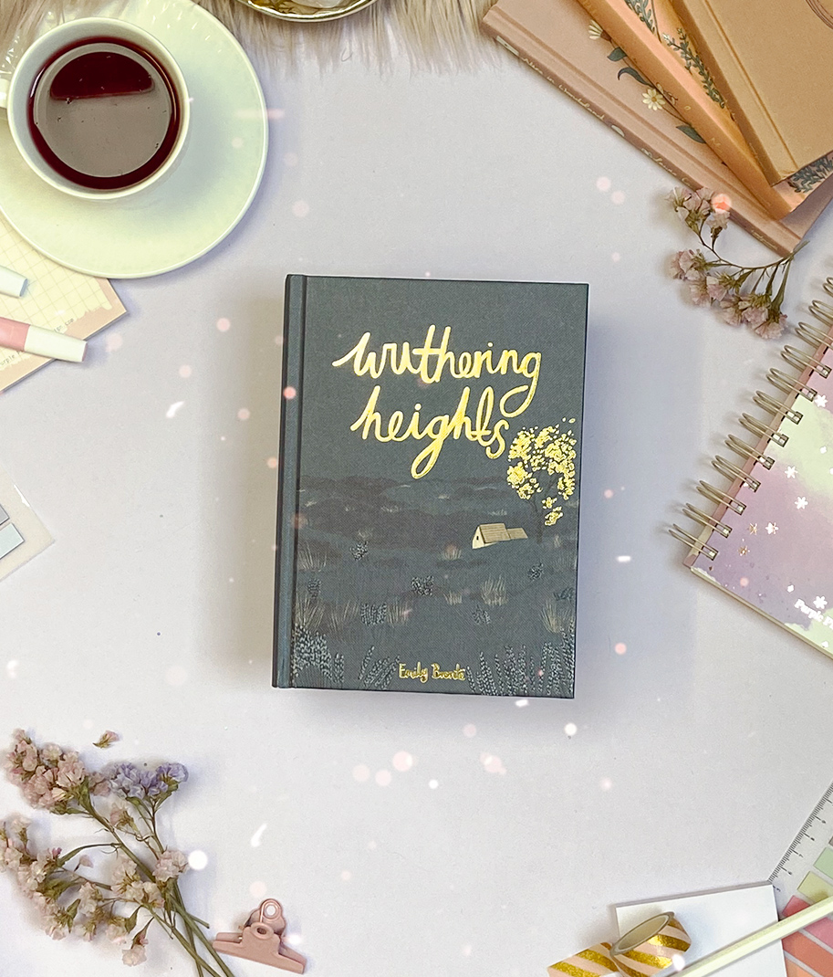 Livro Wuthering Heights numa mesa com chá, flores, caderno e lápis