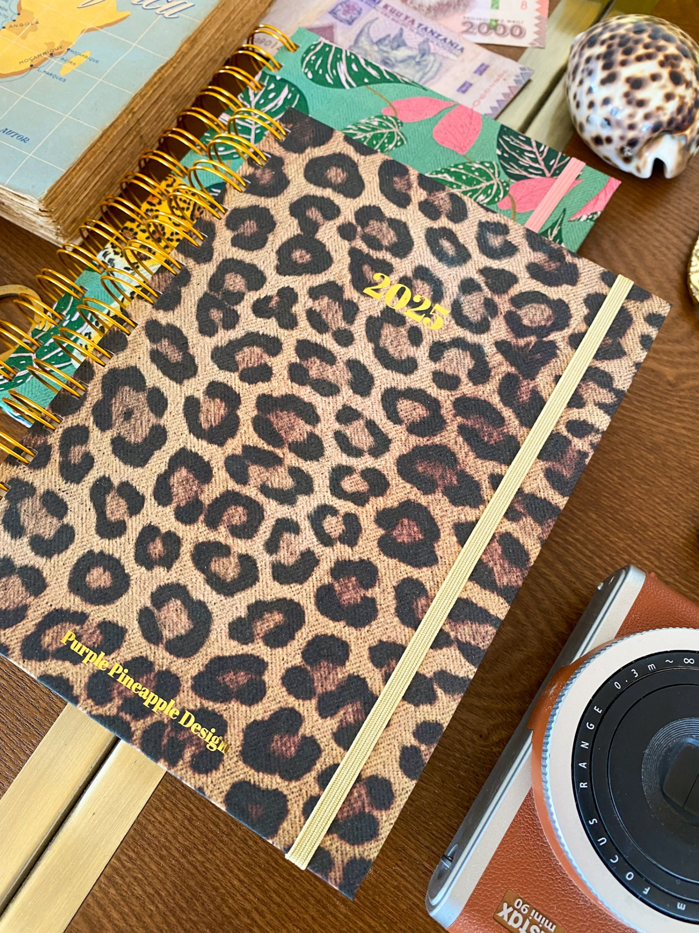 Caderno com capa de padrão leopardo e texto dourado '2022' em superfície de madeira