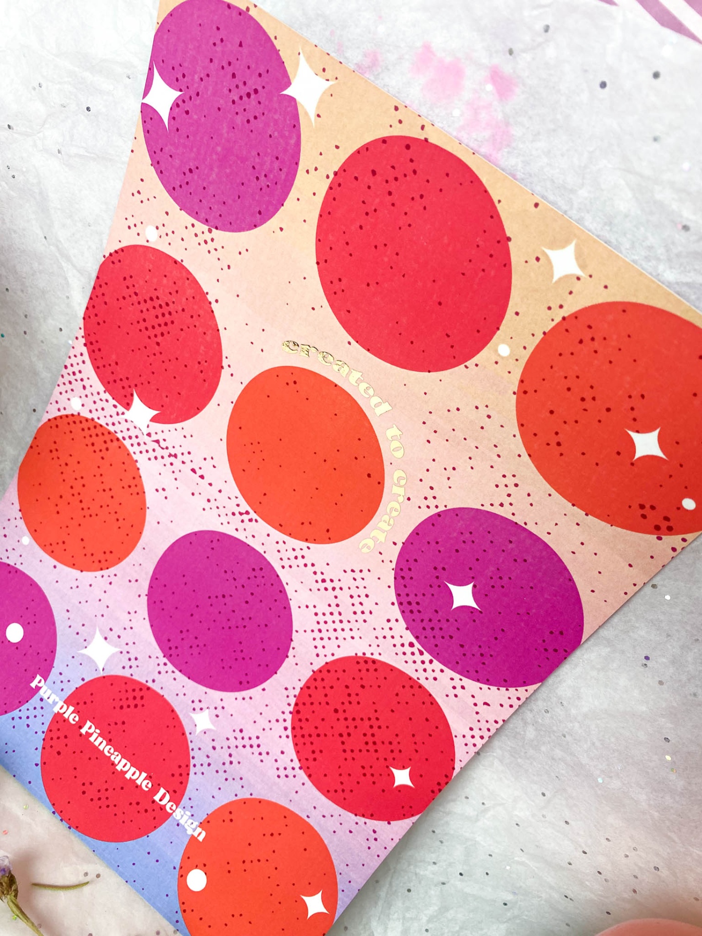 Embalagem colorida com círculos roxos, vermelhos e laranjas e texto CEREMONY OF LOVE e Purple Pineapple Design