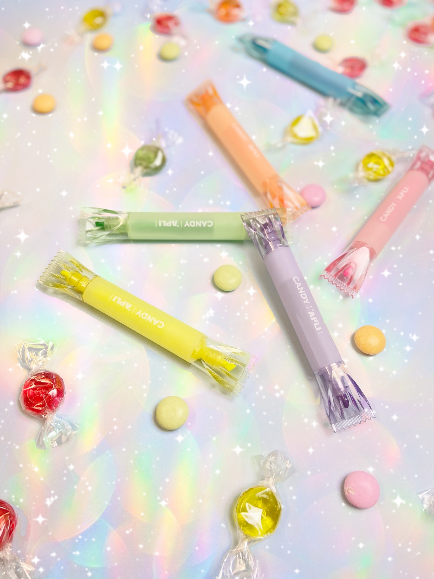 Embalagens coloridas de doces com texto 'CANDY FRUITS' e 'CANDY MINT' em superfície brilhante com confetes e balas