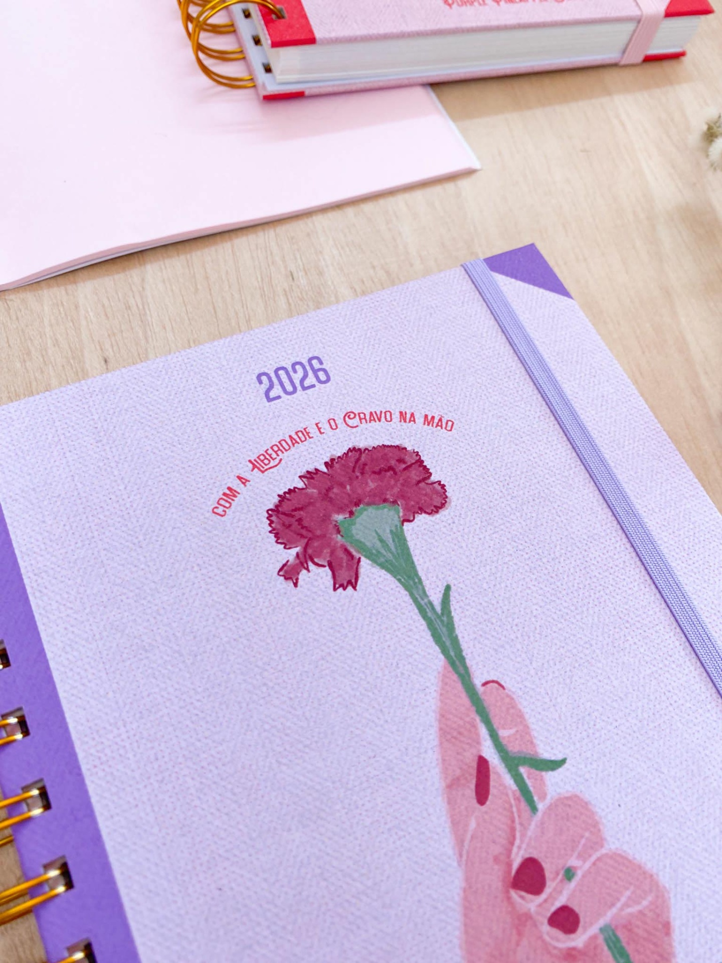 Caderno lilás com flor vermelha e texto sobre a liberdade