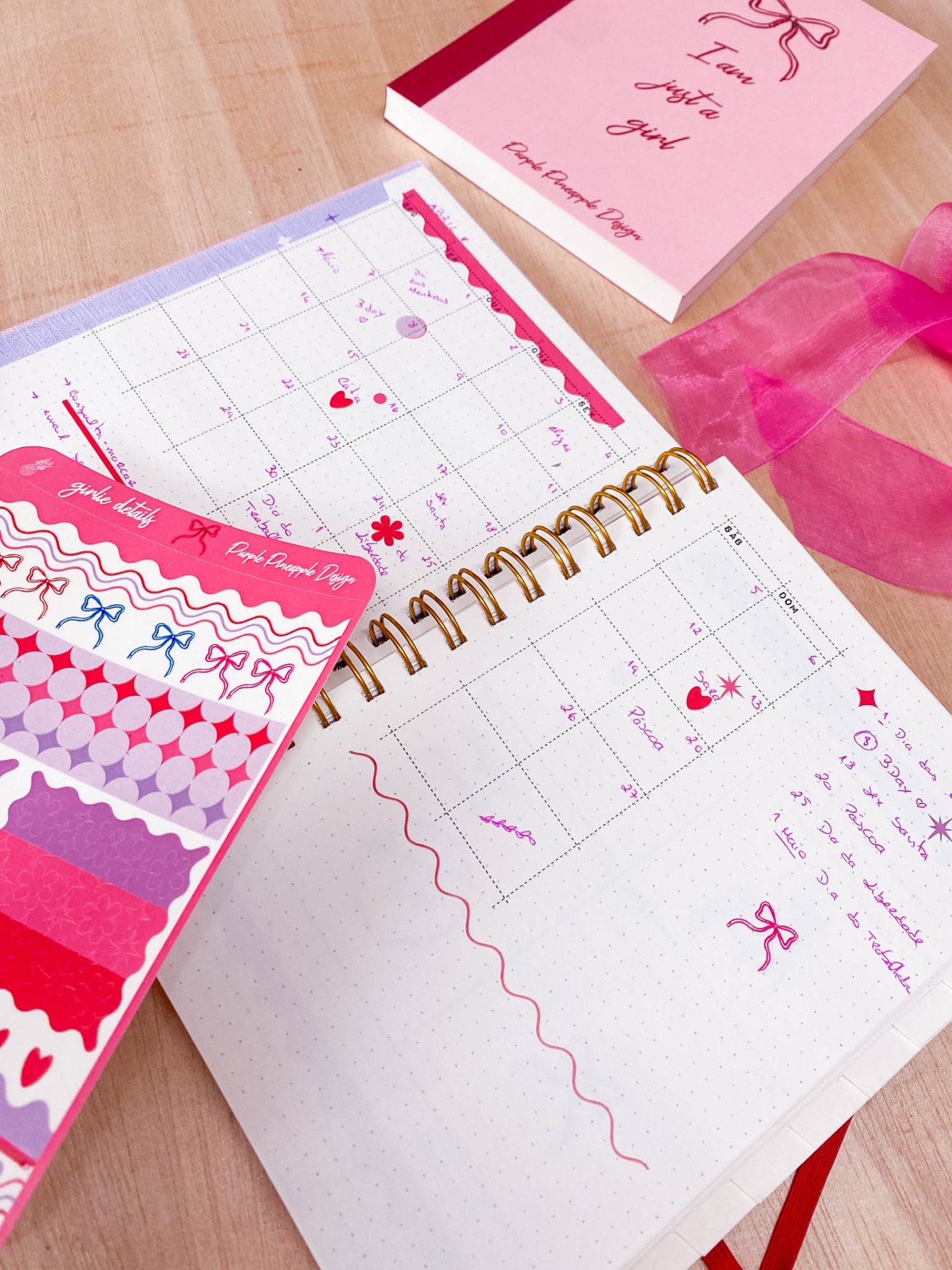 Caderno de organização com autocolantes coloridos e livro rosa com frase motivacional