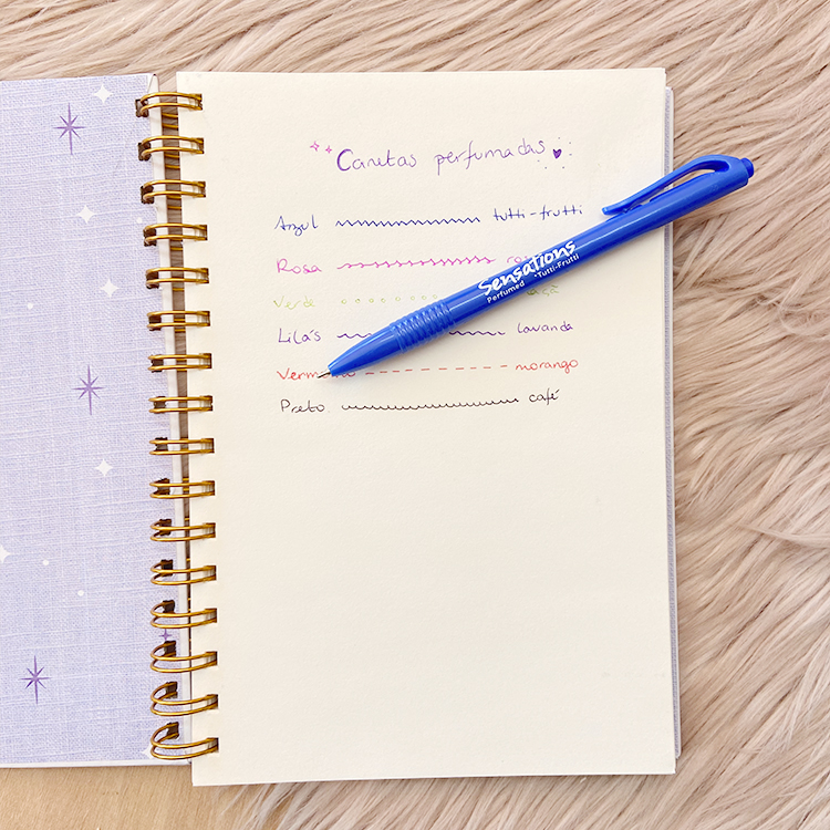 Caderno aberto com texto colorido e caneta azul sobre superfície peluda clara
