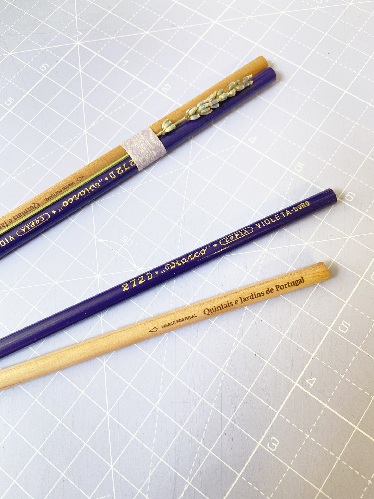 Três lápis de madeira e cor azul sobre mesa quadriculada clara