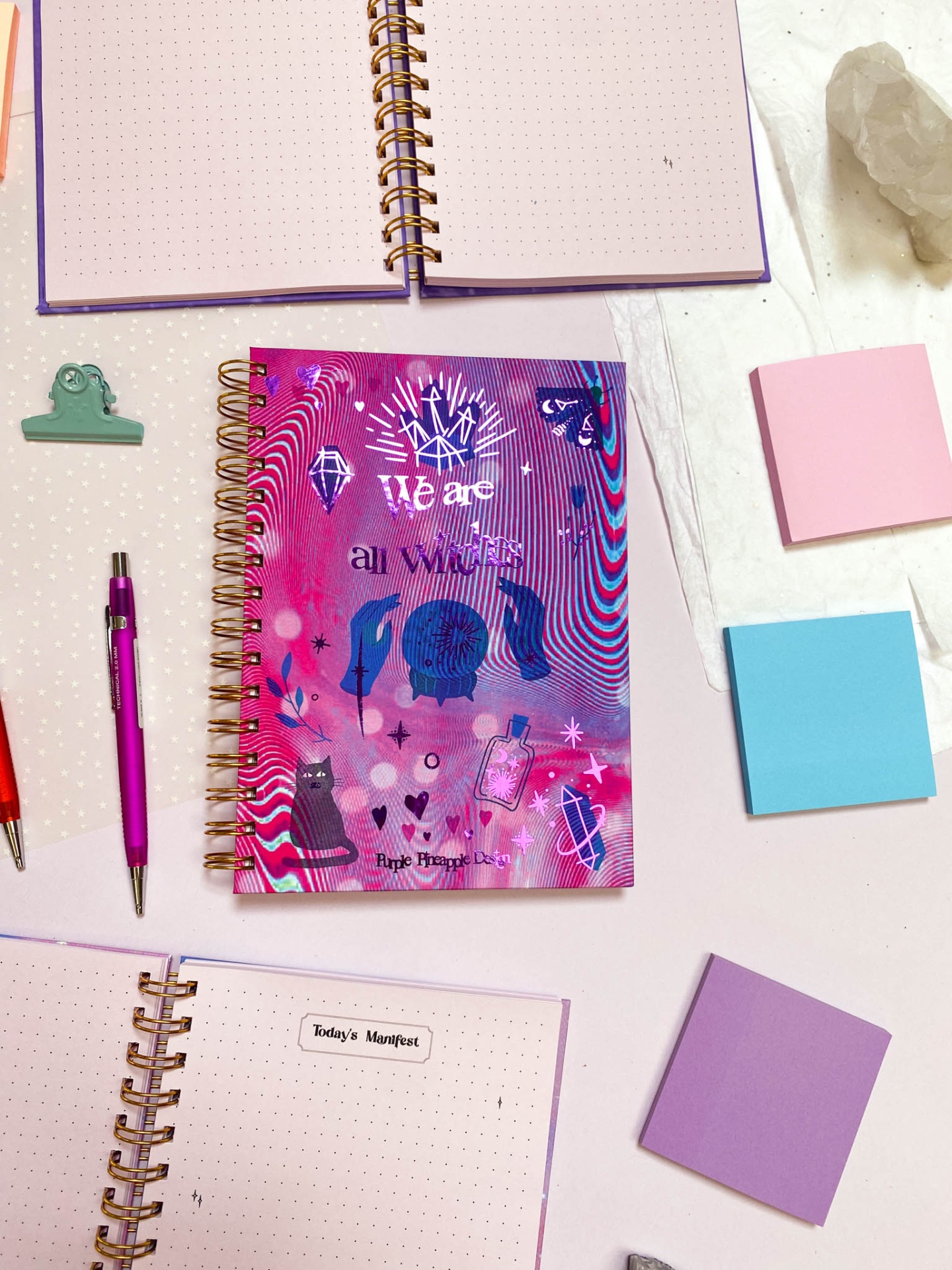 Área de trabalho com cadernos, canetas, clips e post-its coloridos