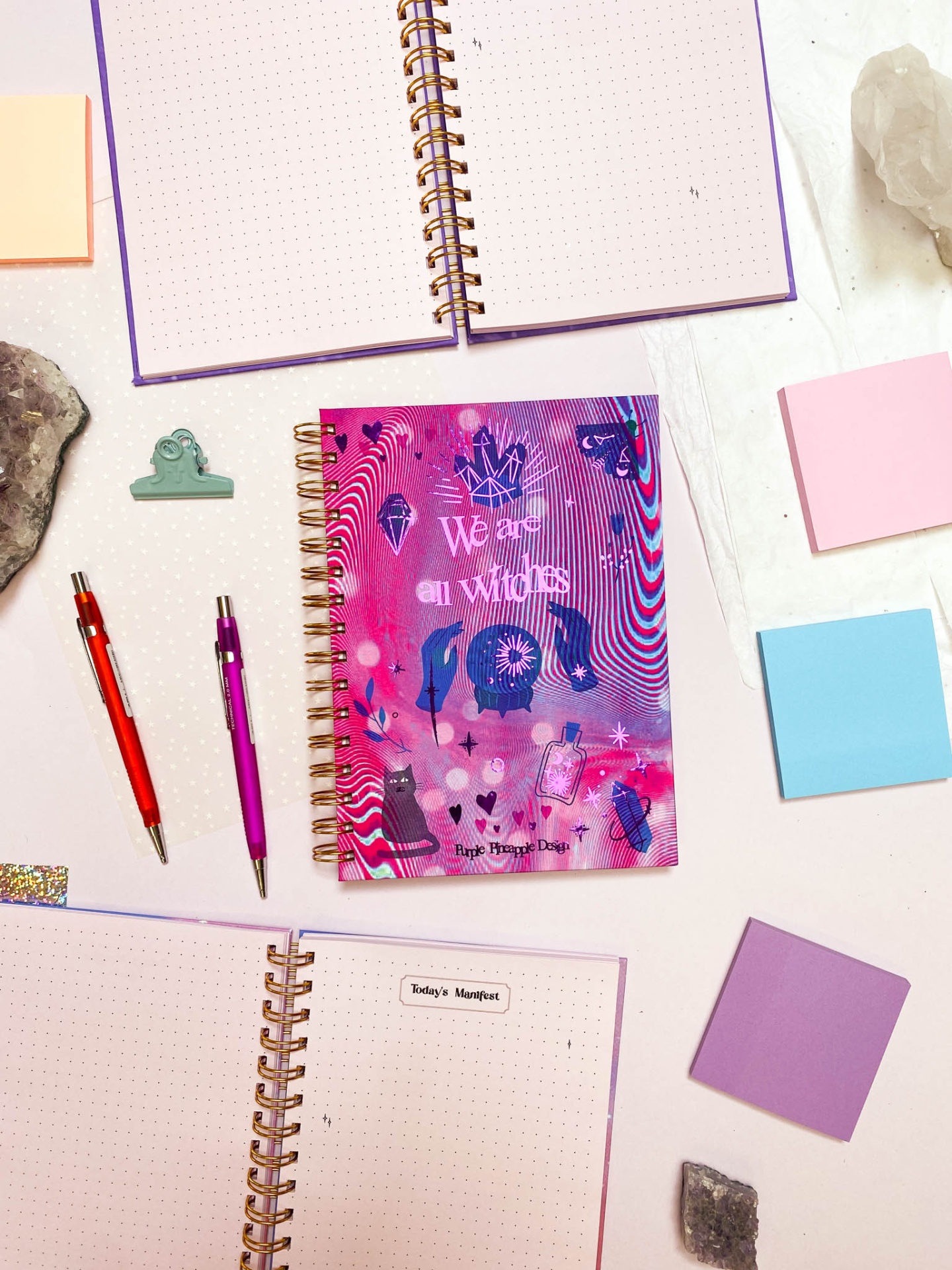 Agenda espiral colorida com ilustrações e vários cadernos e notas adesivas ao redor