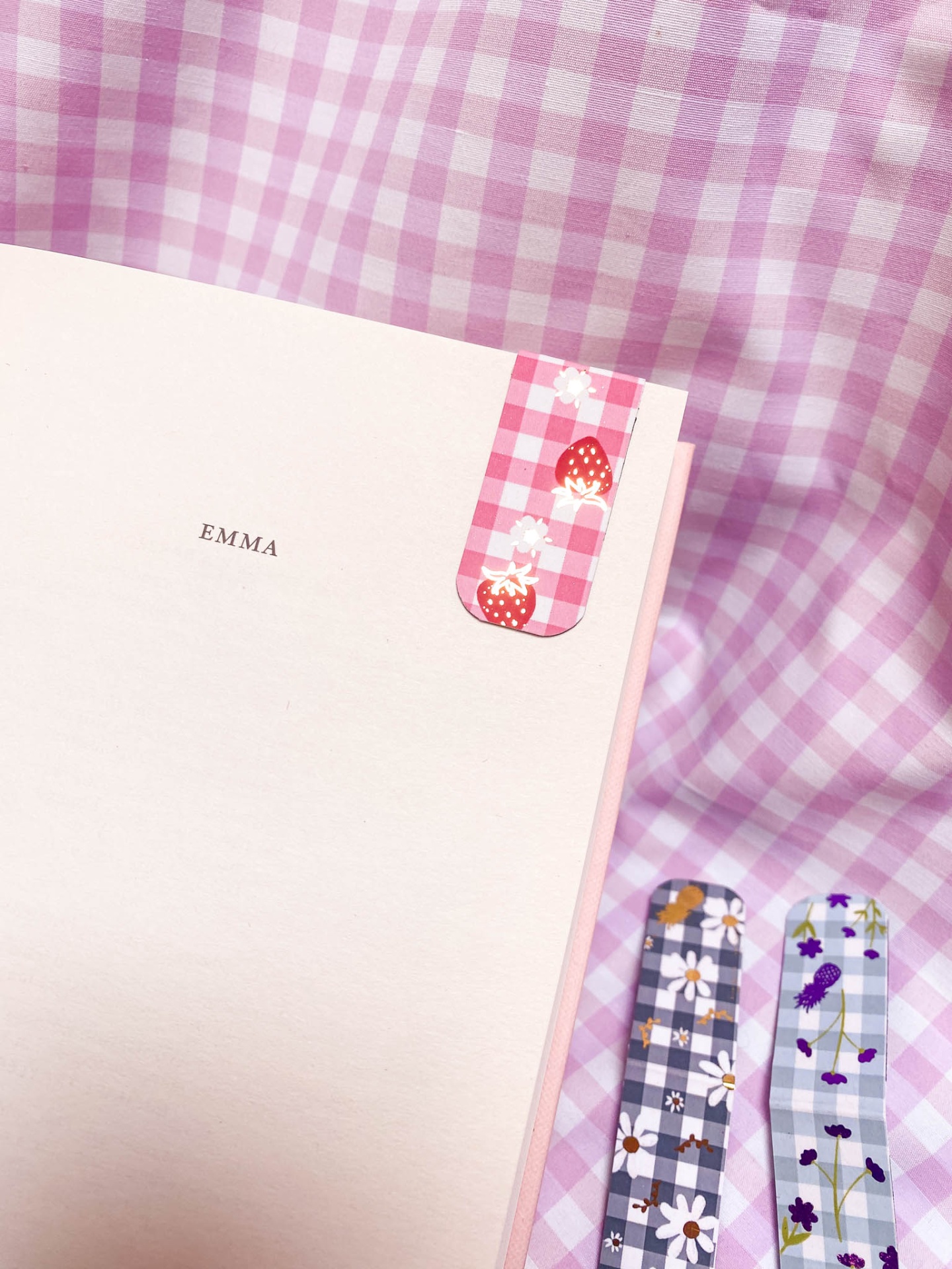 Marcadores de página magnéticos florais e xadrez sobre tecido xadrez lilás