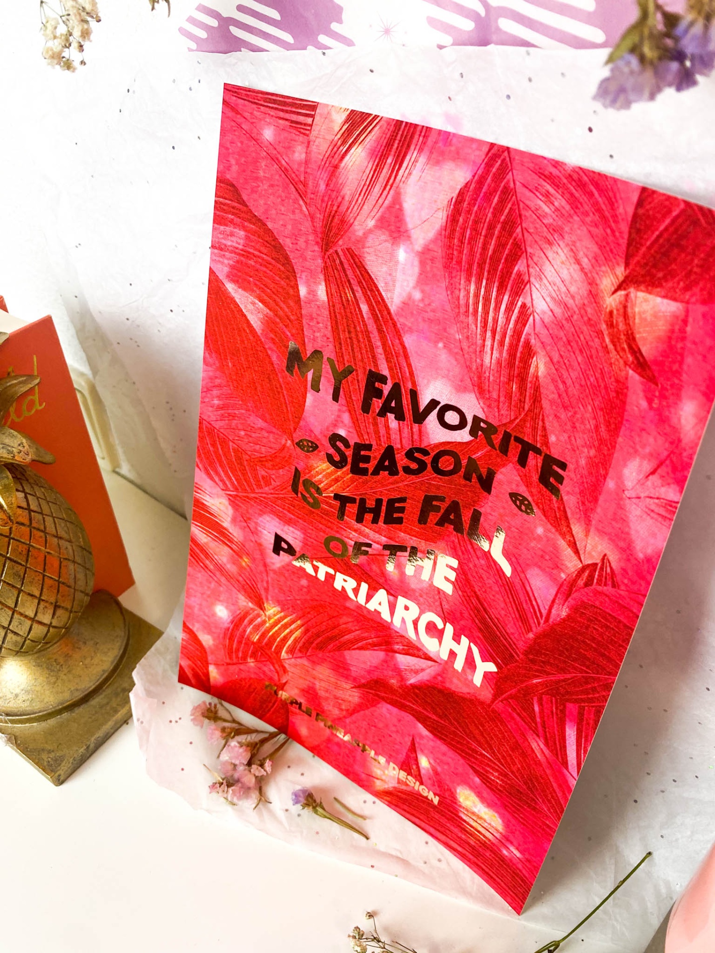 Cartaz vermelho com folhas e texto sobre o fim do patriarcado