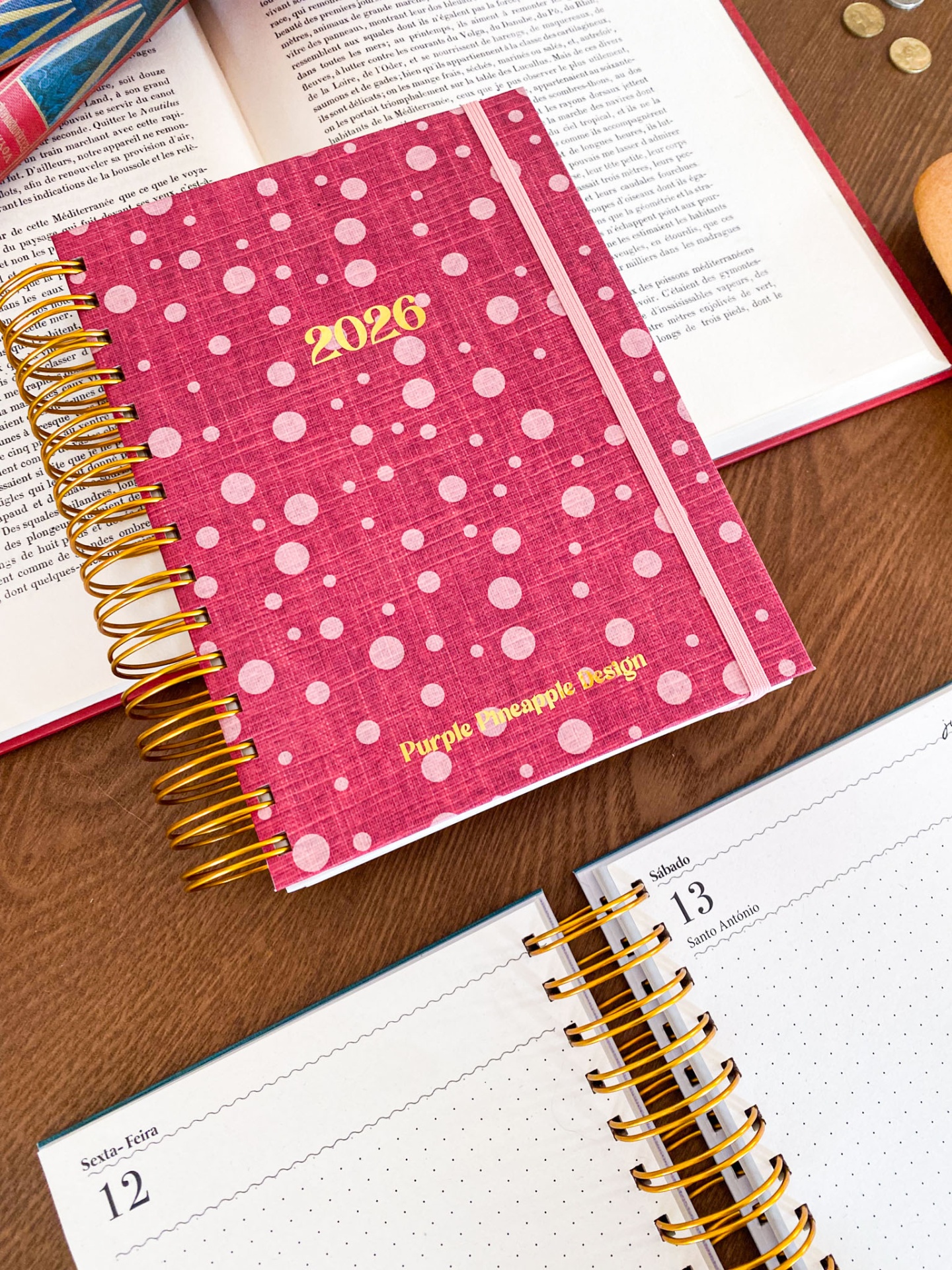 Agenda anual 2026 vermelha com pontos brancos e espiral dourada