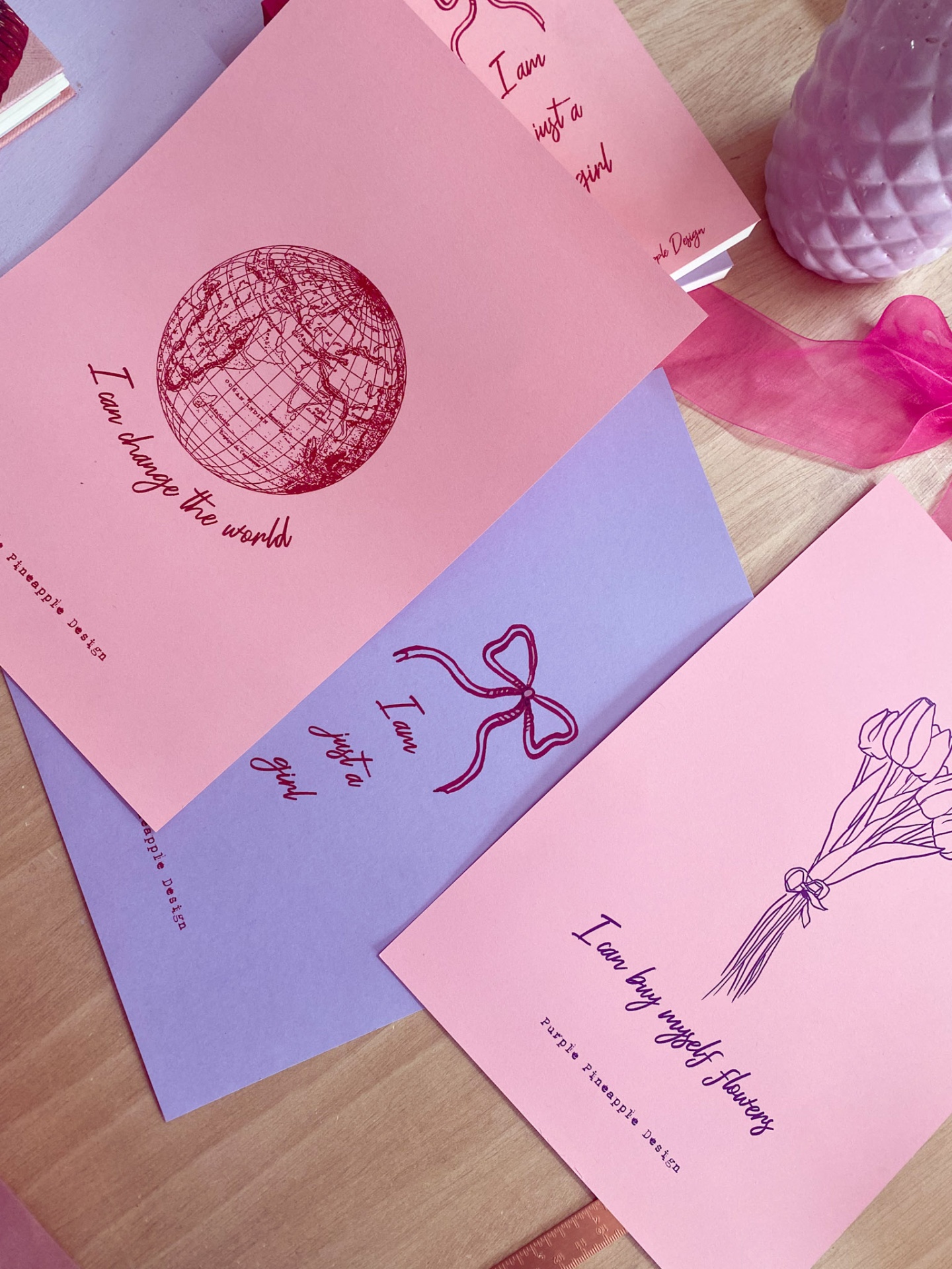 Cadernos coloridos com ilustrações e textos inspiradores sobre uma mesa de madeira clara.