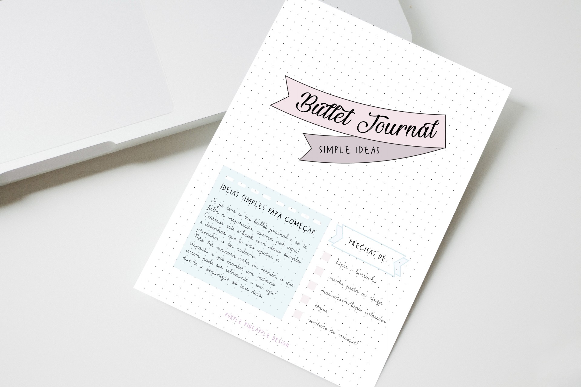 Folha impressa com layout de Bullet Journal ao lado de um portátil