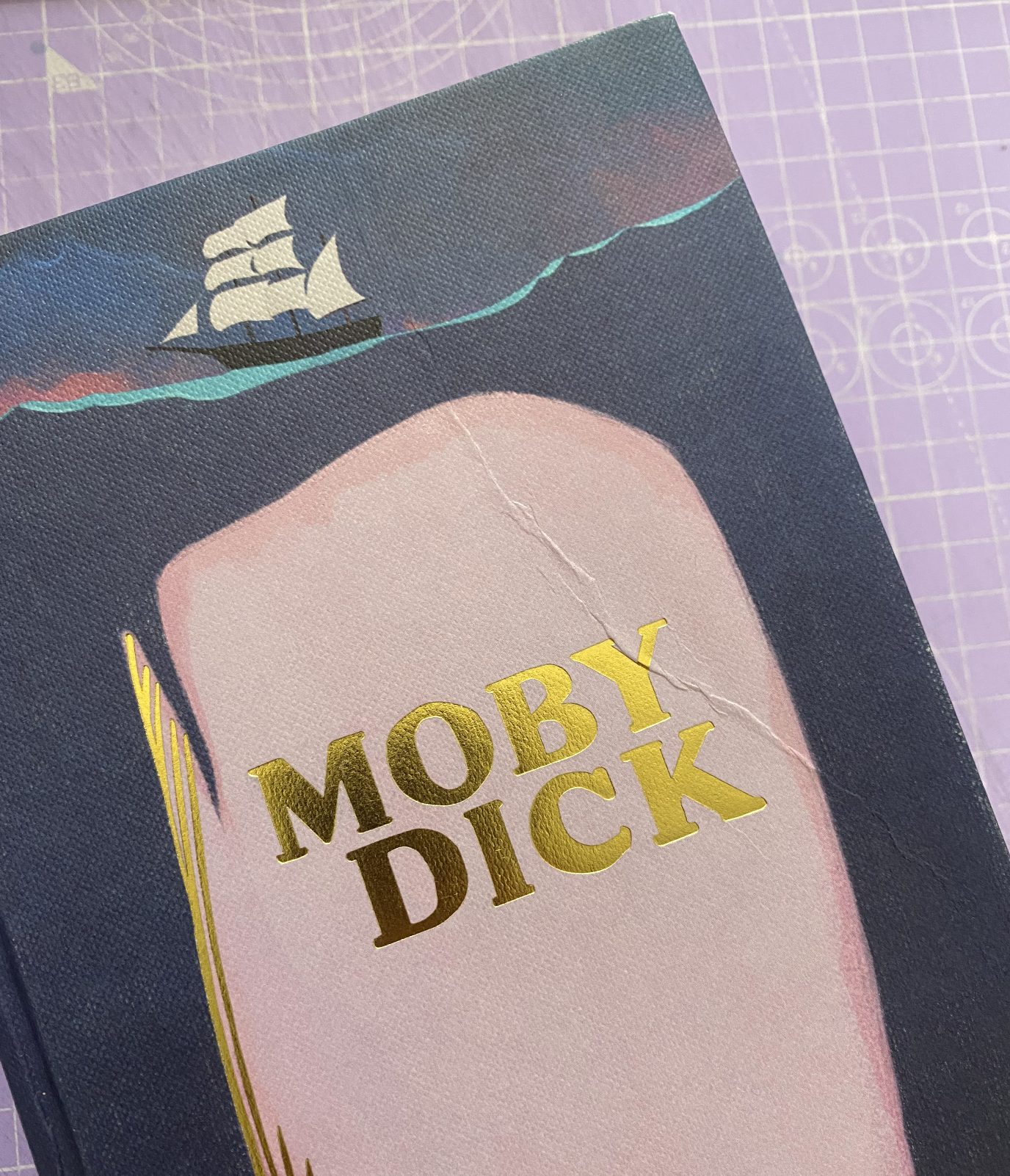 Capa do livro 'MOBY DICK' com design de baleia branca e navio ao fundo