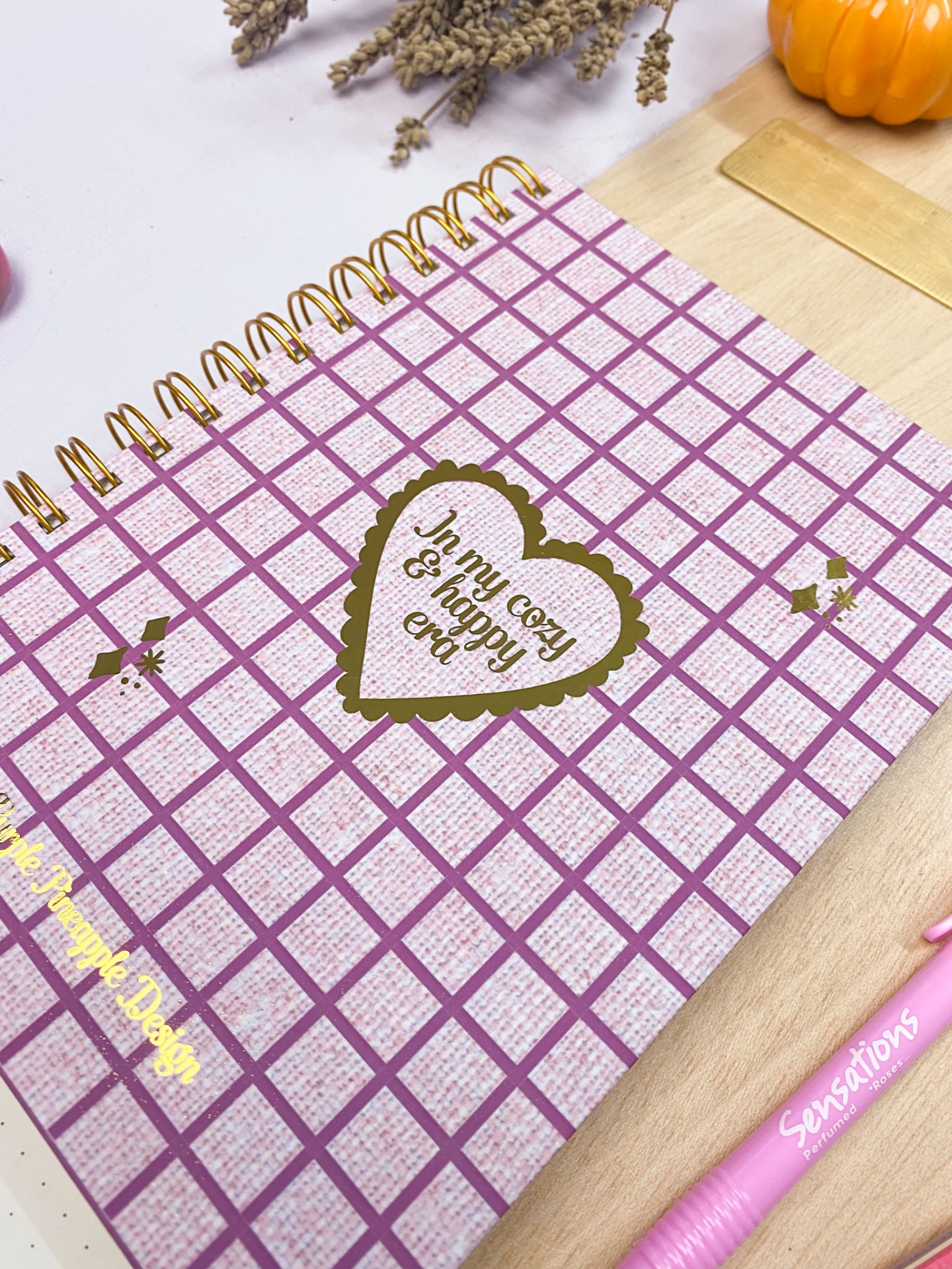 Caderno de argolas com capa rosa e branca xadrez e caneta rosa Sensations